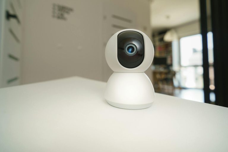 Close-up of a smart home surveillance camera on a table in an interior setting